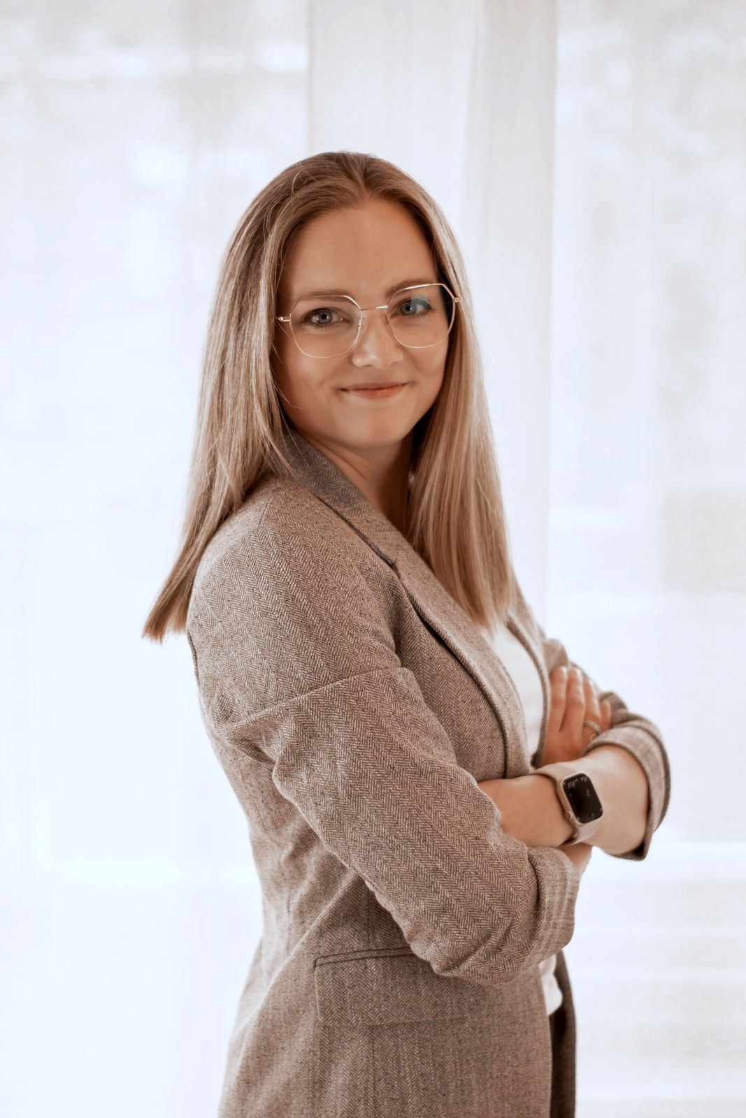 Nora Vehr steht mit verschränkten Armen und lächelt