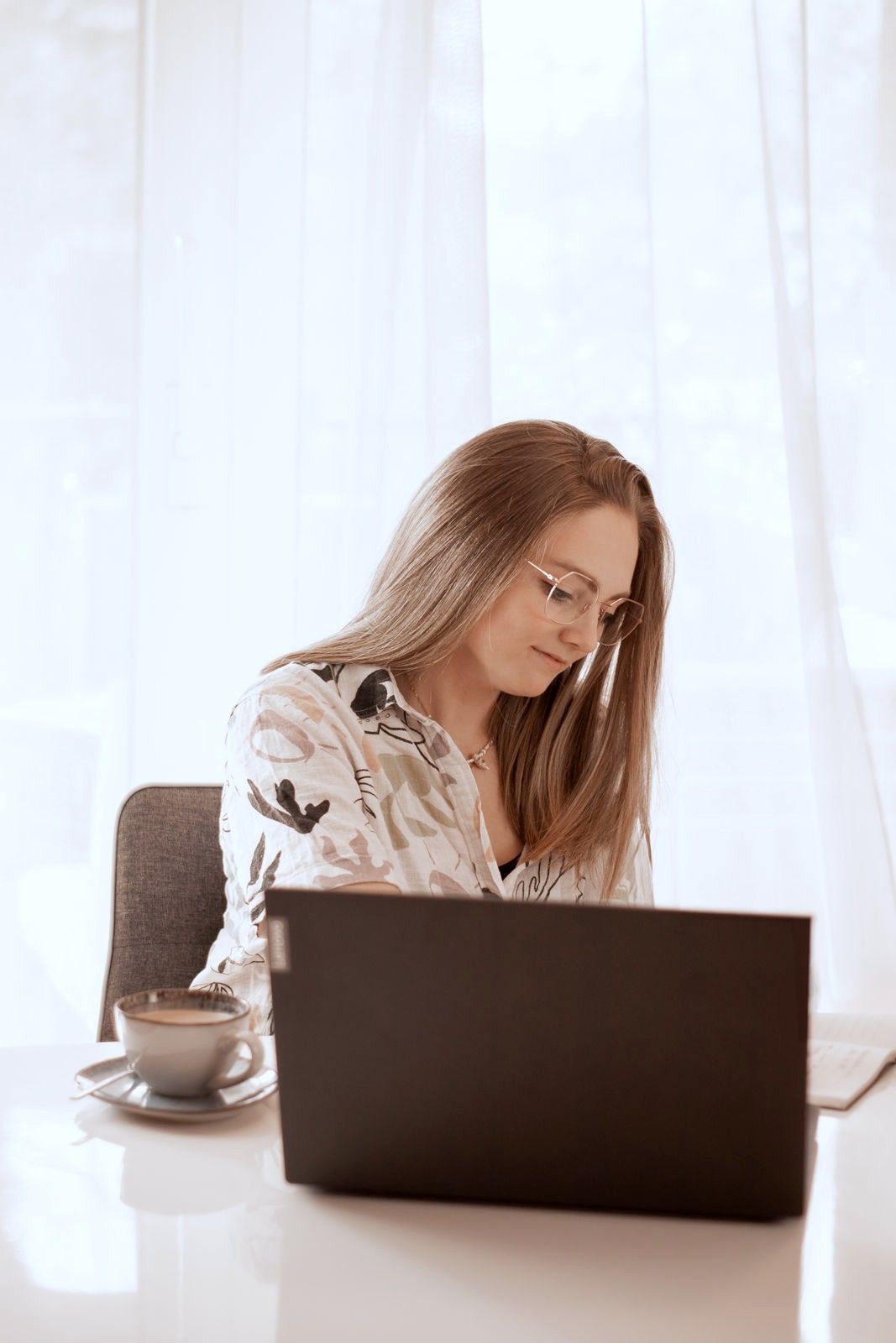 Nora Vehr arbeitet lächelnd am Laptop