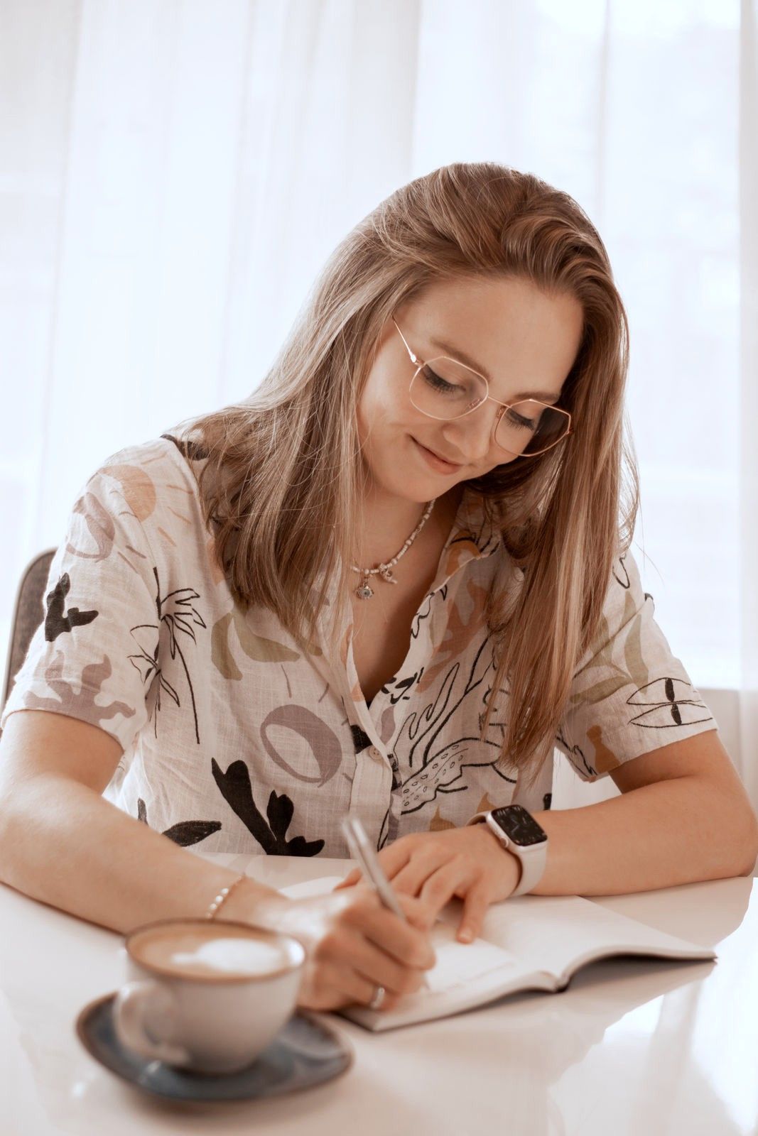Nora Vehr schreibt nachdenklich in ein Notizbuch